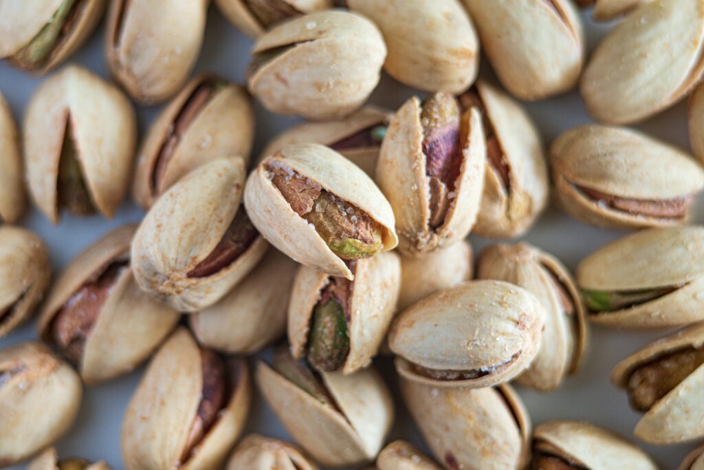 Macro photograph highlighting salted pistachios in their shells, showcasing detail and texture.